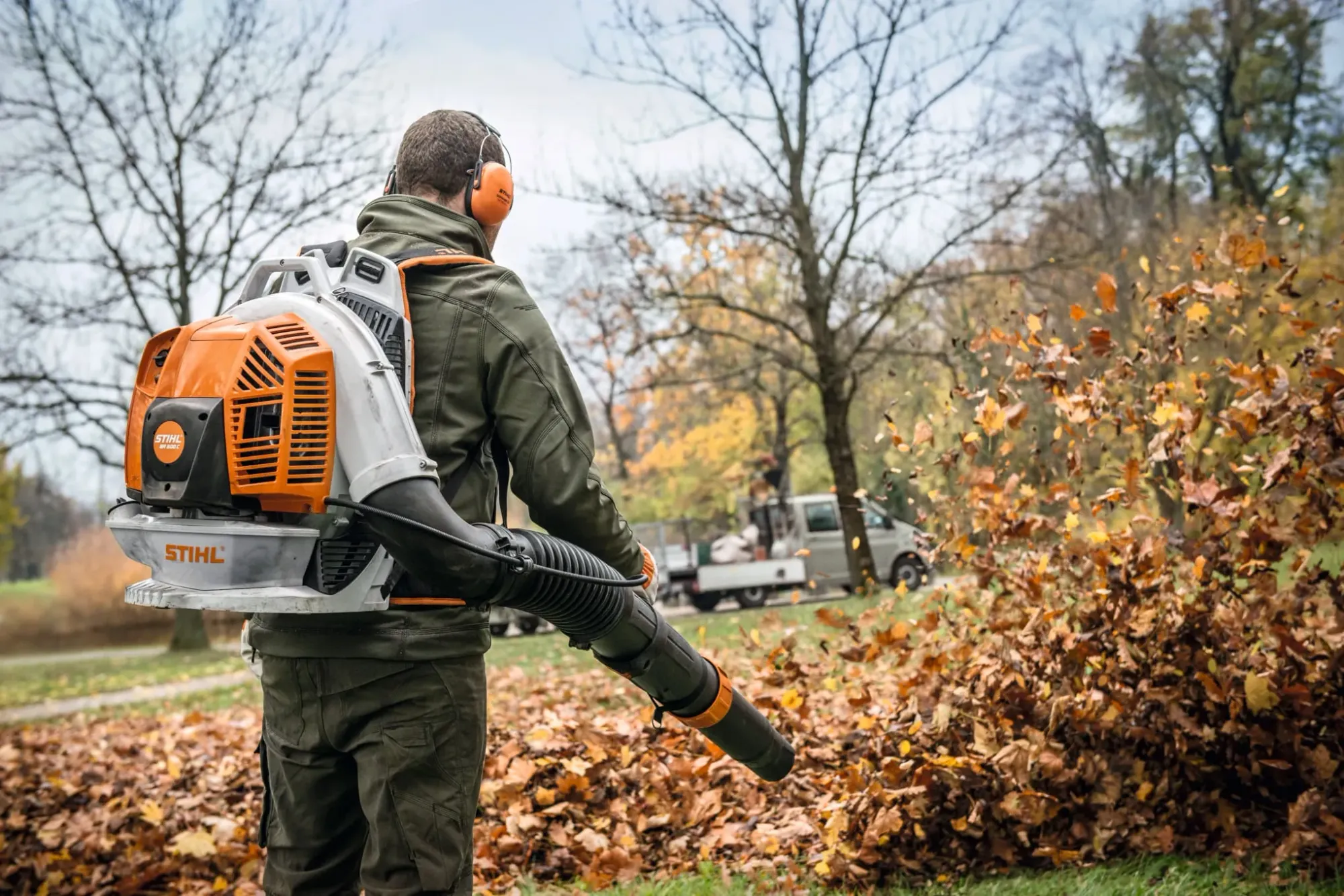 A STIHL leaf blower clearing autumn leaves in a Kiwi backyard