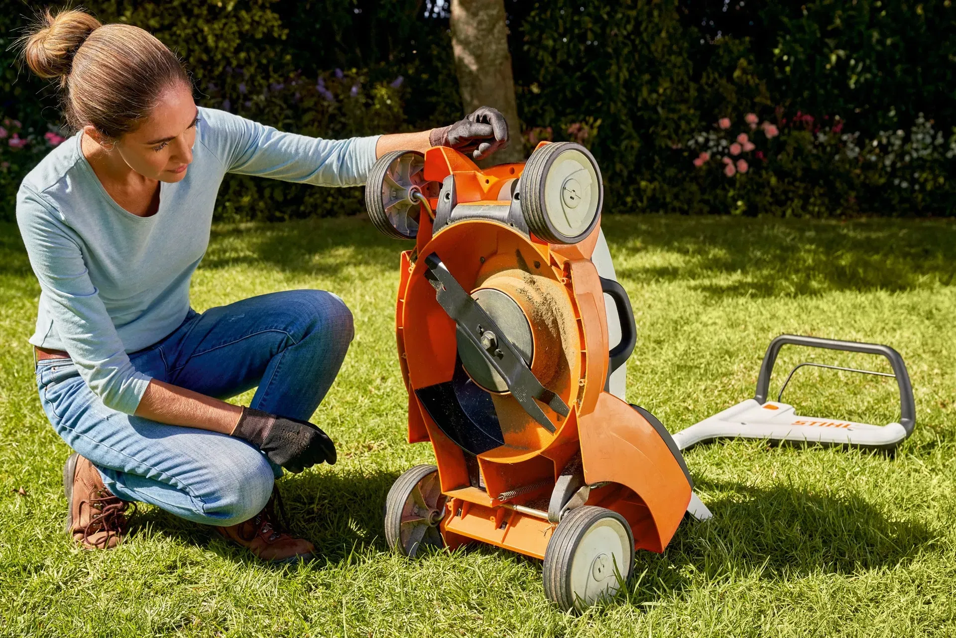 A STIHL technician cleaning and servicing a lawn mower